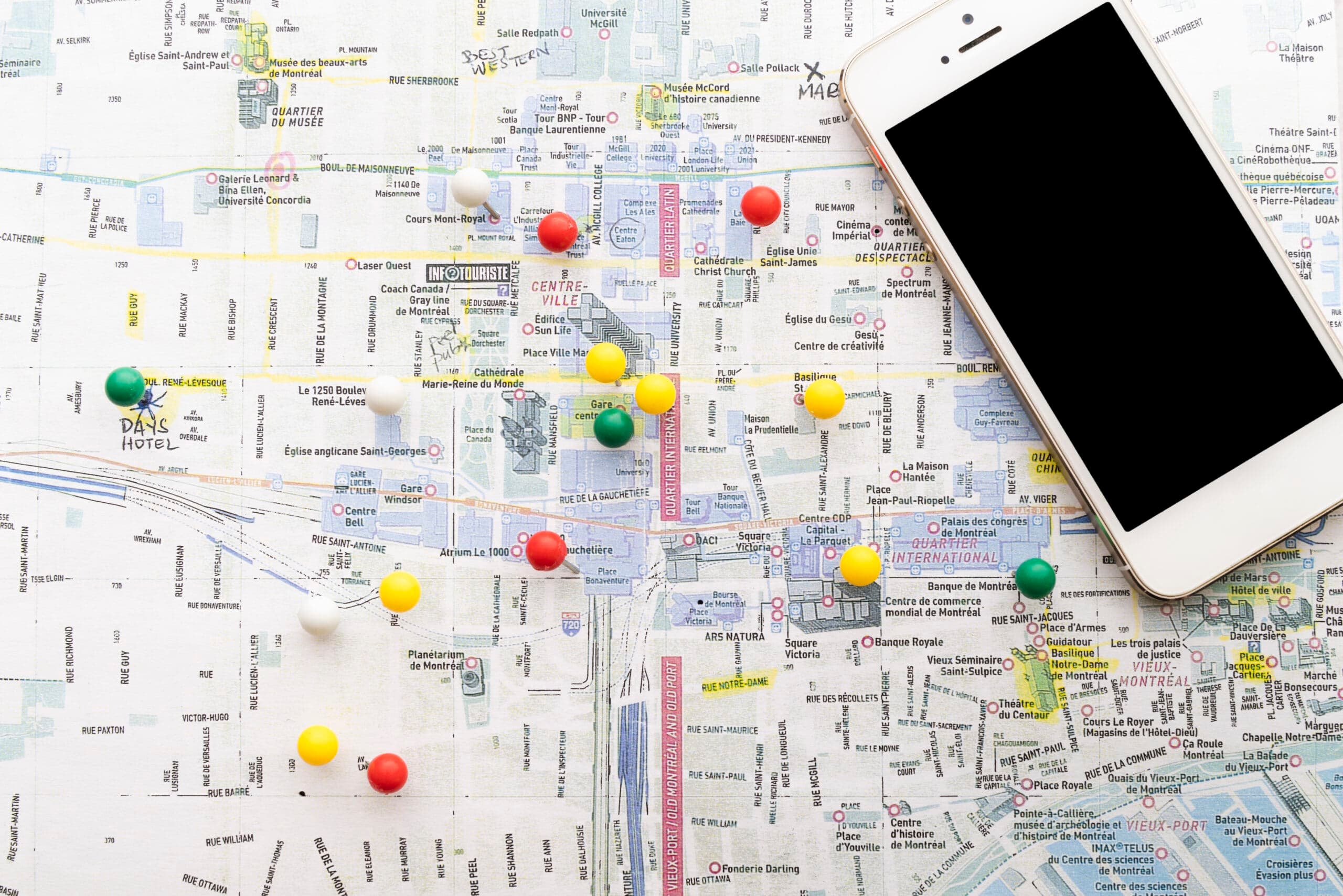 Map with location pins next to a smartphone